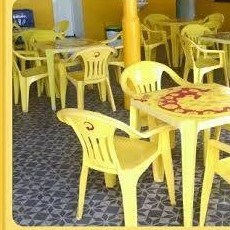 Área de mesas e cadeiras amarelas do Claretes Bar em São Geraldo