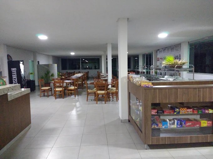 Salão interno do Restaurante Estação de Minas, com mesas e buffet